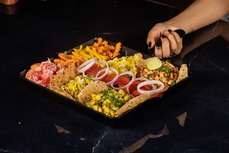 Bunt angerichtete Snackplatte mit frischem Gemüse, Mais und Dips