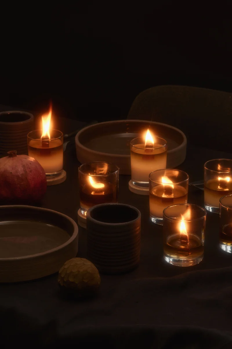 Festlich gedeckter Tisch im Kerzenschein mit Granatapfel und Keramikgeschirr